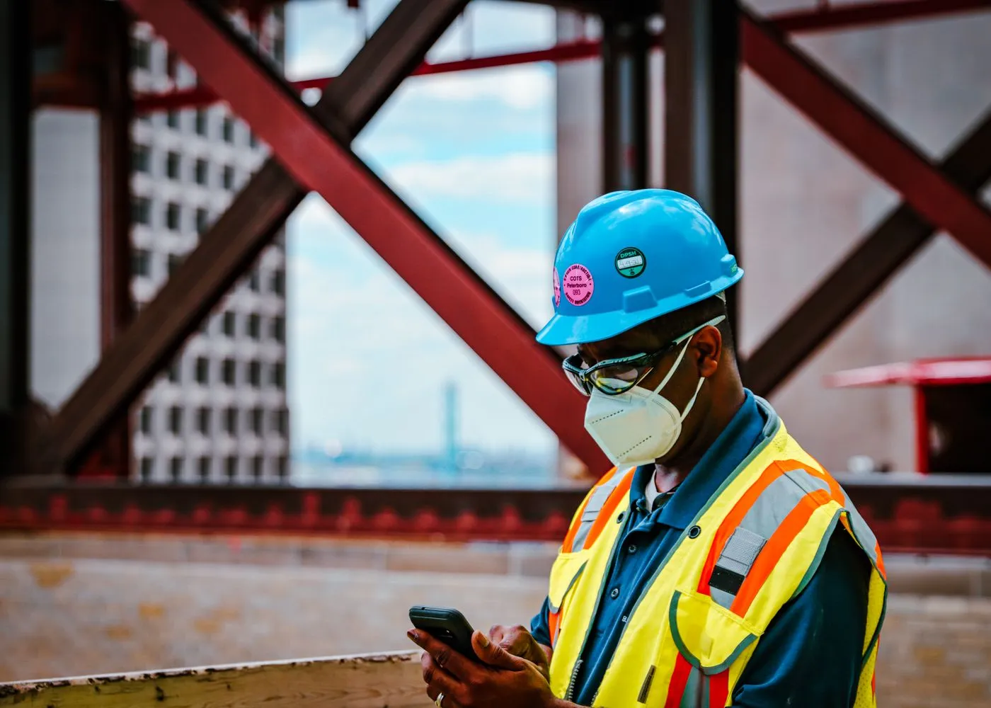 Site manager checking the Sitewise app on a steel-framed construction site