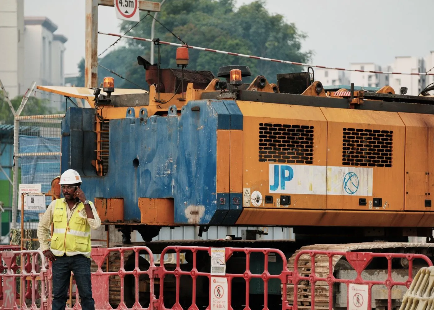 A subcontractor checking a phone on a construction site